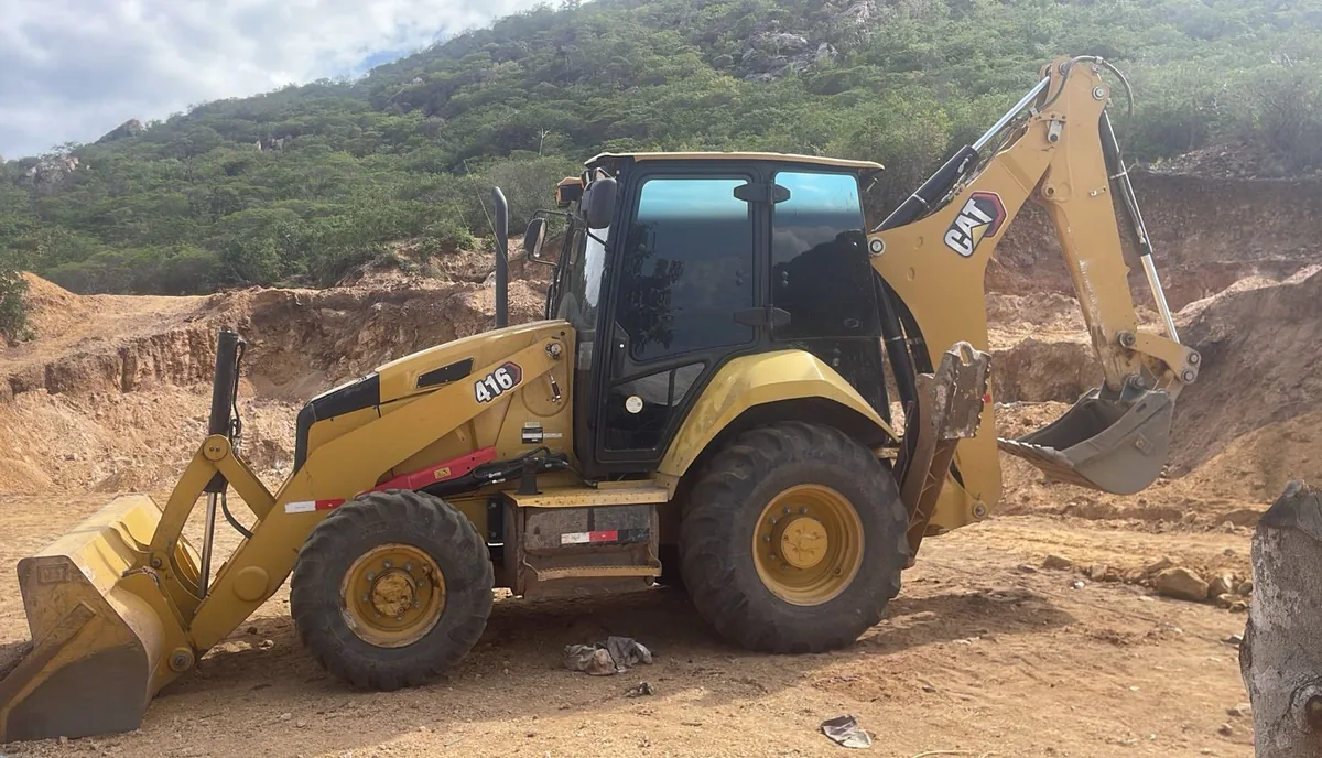 Retroescavadeira do Grupo BCM posicionada em frente de serviço, em área de terraplenagem